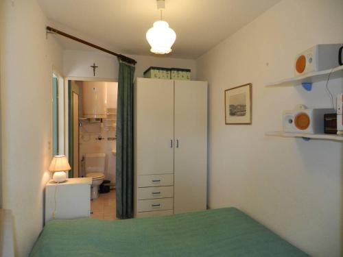 - une chambre avec une armoire blanche et une salle de bains dans l'établissement Appartement 2 pièces avec terrasse et piscine, La Londe-les-Maures - FR-1-826-9, à La Londe-les-Maures