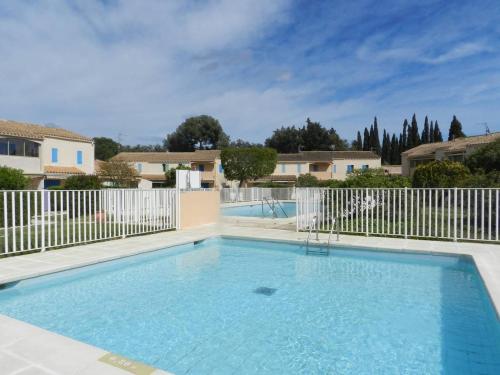 une grande piscine avec une clôture blanche dans l'établissement Appartement 2 pièces avec terrasse et piscine, La Londe-les-Maures - FR-1-826-9, à La Londe-les-Maures