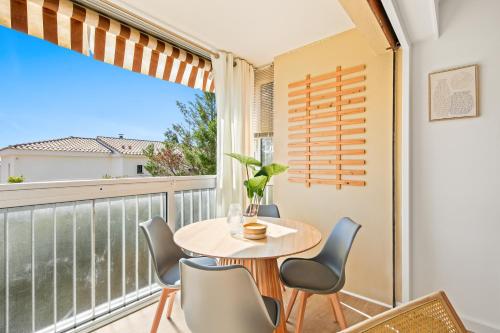 a balcony with a table and chairs and a window at T2 Paisible in Carqueiranne