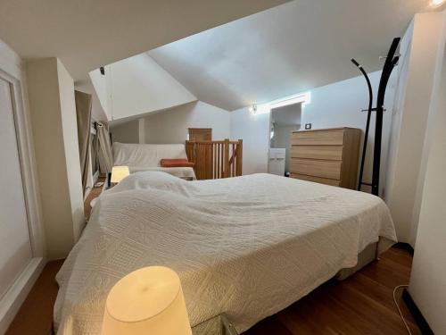 une chambre avec un grand lit blanc et une chaise dans l'établissement Appartement moderne 2 pièces avec balcon et parking à La Londe-les-Maures - FR-1-826-2, à La Londe-les-Maures