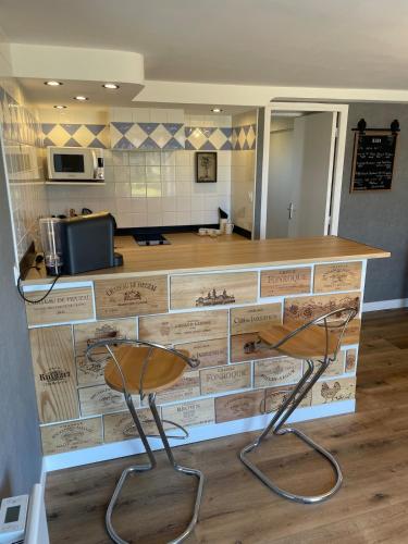 un comptoir avec deux chaises dans une pièce dans l'établissement Air Pyrénées, à Huos