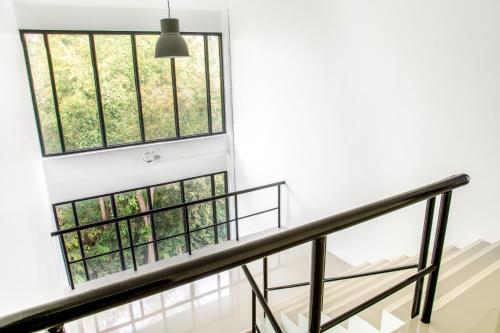 a staircase with three windows in a house at Grand Sattahip Hotel by BSH in Ban Nong Sa