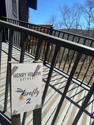 a sign on a fence with a honey holly retreat on it at Firefly2 - luxury lakeside treehouse with hot tub in Eureka Springs