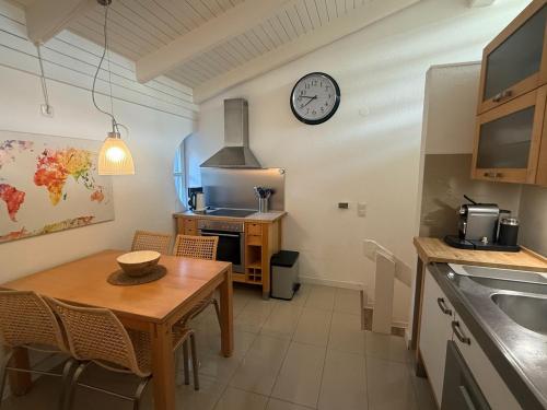 a kitchen with a table and a clock on the wall at Ankerplatz Dangast in Dangast
