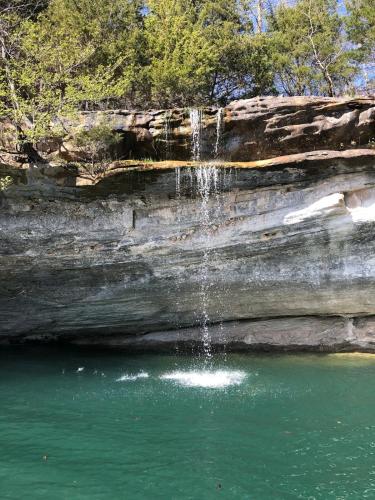 a waterfall in the middle of a pool of water at Firefly2 - luxury lakeside treehouse with hot tub in Eureka Springs