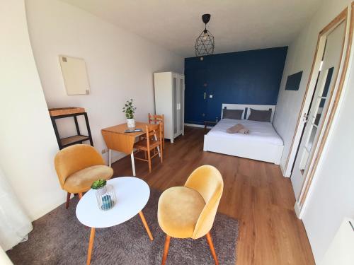 une petite pièce avec un lit, une table et des chaises dans l'établissement Appartement T1 cosy- terrasse - parking gratuit, à Montpellier