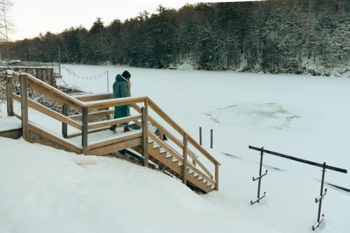 a person standing on a wooden bridge in the snow at Peaceful Catskills Creek House in Saugerties