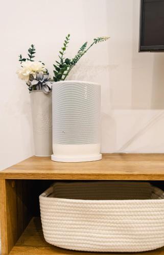 a speaker sitting on top of a wooden shelf with flowers at Peaceful Catskills Creek House in Saugerties
