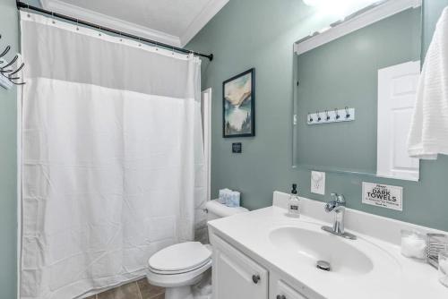 a bathroom with a white toilet and a sink at DockTales - Panoramic Views & Private Dock in Six Mile