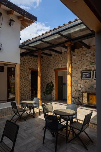 a patio with tables and chairs and a stone wall at Corazón Del Café Hotel Boutique in Comitán