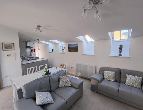 ein Wohnzimmer mit Sofa und Tisch in der Unterkunft Goviers Cottage in Sidmouth