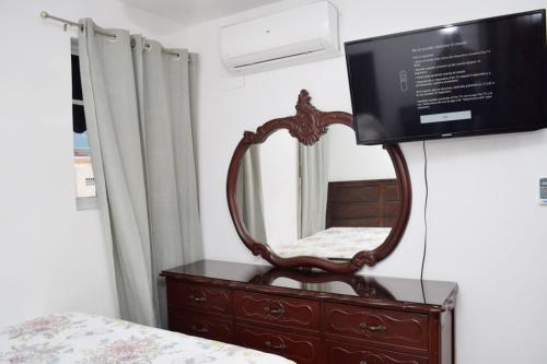 a mirror on a dresser with a television on it at Relax in this apartment in Santiago de los Caballeros