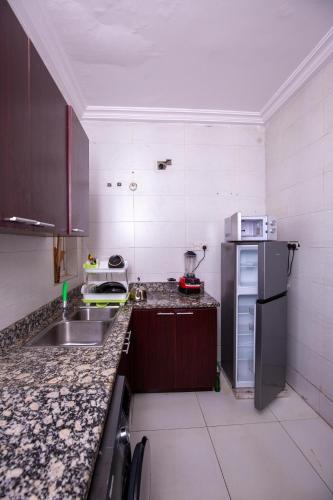 a kitchen with a sink and a refrigerator at 2 Bedroom Furnished Serviced Apartment in Lekki Phase 1 in Lekki