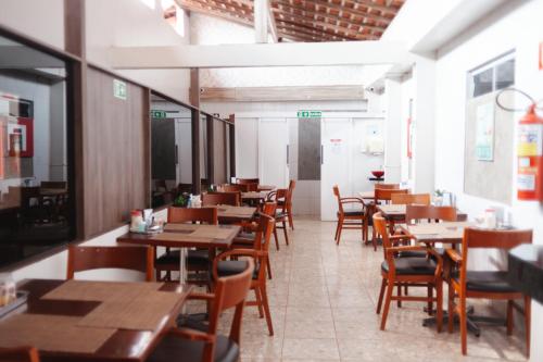 a dining room with wooden tables and chairs at Hotel Indiana in Paragominas