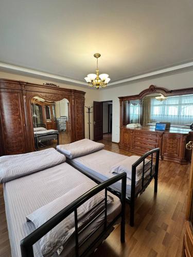 a bedroom with two beds and a chandelier at Квартира в центре in Tashkent