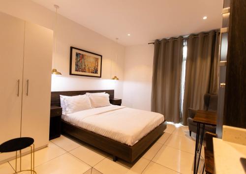 a hotel room with a bed and a desk at Central Studio Suite at Embassy Gardens in Accra