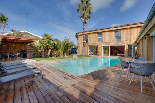 une terrasse avec une piscine et une maison dans l'établissement Stunning Villa 10p, with pool, à Seignosse