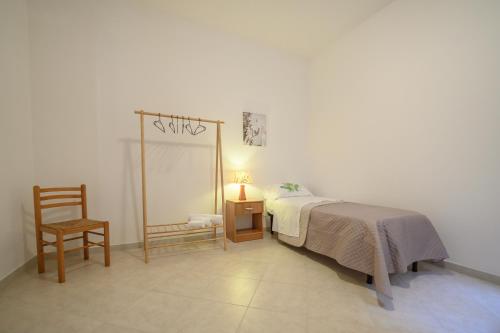 a bedroom with a bed and a chair and a mirror at La home di Antonio in Marsala