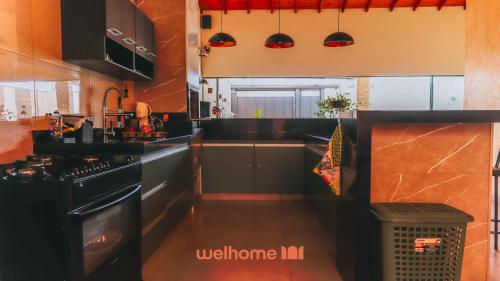 a kitchen with black cabinets and a sink at Casa incrivel em Bebedouro com piscina e lazer in Bebedouro