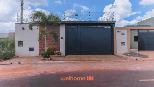 a black garage door on a white building at Casa incrivel em Bebedouro com piscina e lazer in Bebedouro