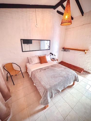 a bedroom with a bed and a chair in it at Elena Coffee Hostel Lago Calima Darién in Darién
