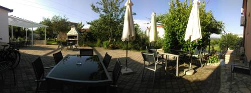 a patio with a table and chairs and umbrellas at Casa Bevanda in Međugorje