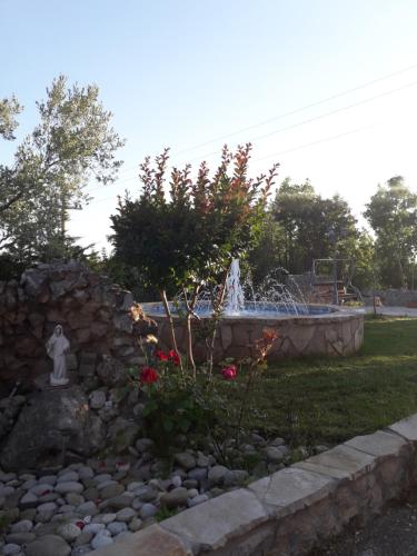 a fountain in a garden with a stone wall at Casa Bevanda in Međugorje
