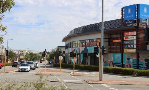 a building on a street with cars parked in a parking lot at Come and dine with me at Jo in Baldivis