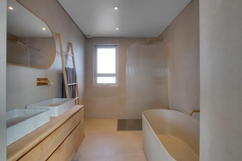 une salle de bain avec une baignoire, un lavabo et un miroir dans l'établissement Stunning Villa 10p, with pool, à Seignosse