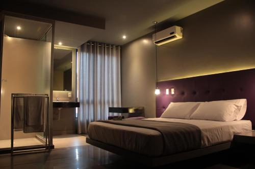a bedroom with a large bed and a mirror at G Hotel by Gaya Group in Santa Cruz de la Sierra