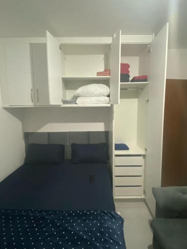 a small bedroom with a bed and white cabinets at Apto Novo Jardim Rosinha 04 in Sao Paulo