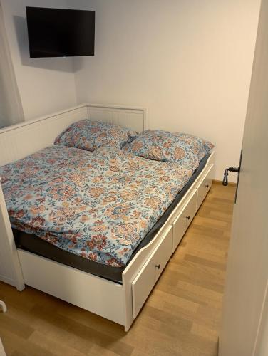 a bed with a floral comforter in a bedroom at Apartmán Kafíno in Nové Město na Moravě
