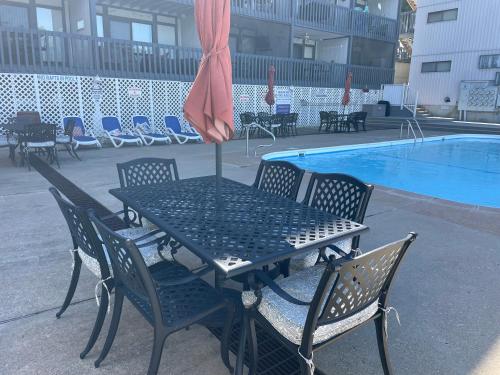a table and chairs next to a swimming pool at STAIRS OPTIONAL! Lakefront! Pool! On Water! Convenient Fishing! in Osage Beach