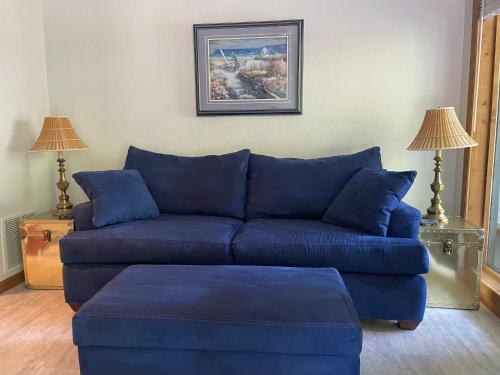 a blue couch in a living room with two lamps at STAIRS OPTIONAL! Lakefront! Pool! On Water! Convenient Fishing! in Osage Beach
