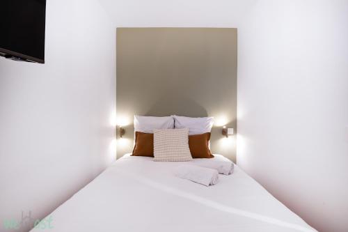 1 cama blanca con 2 almohadas y TV en Sublime 2-bedroom apartment - Historical center, en Burdeos