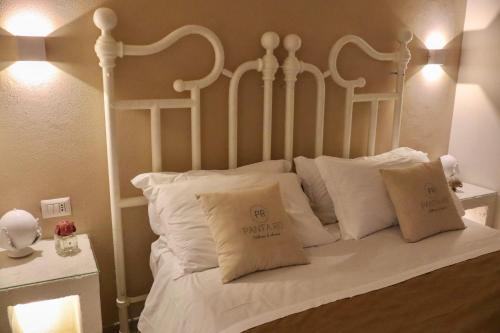 a white bed with white pillows on it at Panta Rei Wellness & Charme Monopoli in Monopoli