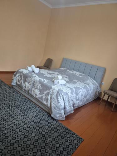 a bedroom with a bed with a gray comforter at Cozi apartment Arsha in Gaiboteni