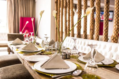 a dining table with plates and napkins on it at The Swiss Hotel Freetown in Freetown