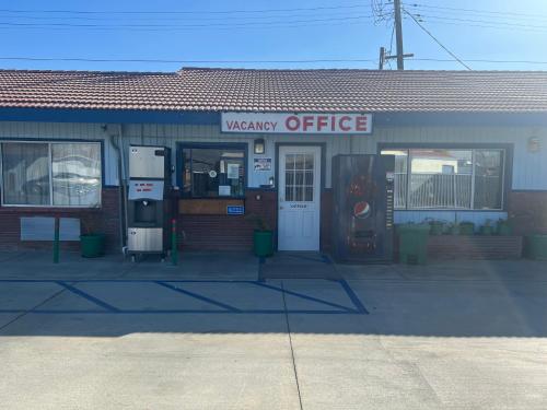 a mercy office building with a gas pump in front at City Center Motel Indio in Indio