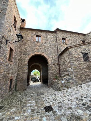 an entrance to a brick building with an archway at Castello di Piagnano in Caprazzino