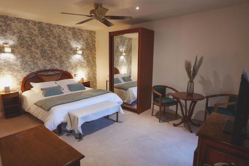 une chambre avec un grand lit et un miroir dans l'établissement Auberge Du Cheval Blanc - Teritoria, à Selles-Saint-Denis