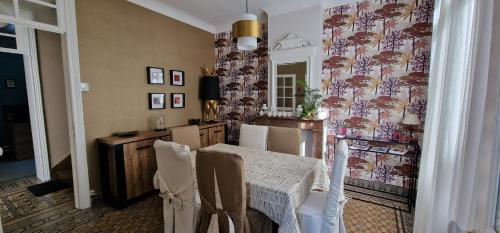 une salle à manger avec une table et une table et des chaises dans l'établissement Maison, au plus prés du centre ville et du Beffroi, 3 chambres et 1 Chambre de bébé, à Béthune
