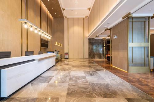 an office lobby with a long reception desk and a lobby at Echarm Plus International Hotel Ouzhuang Metro Station Branch - Free Deliver Service to Canton Fair Complex During Canton Fair Period in Guangzhou