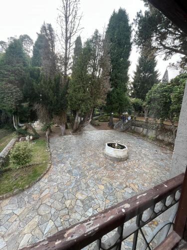 a stone patio with a fire pit in a garden at Palacio Conde Toreno in Malleza