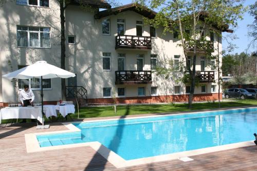 a hotel with a swimming pool in front of a building at Viktoria Park Hotel in Bucha