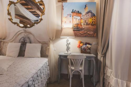 a bedroom with a bed and a table and a mirror at La Romantica Lolo' in Montepulciano