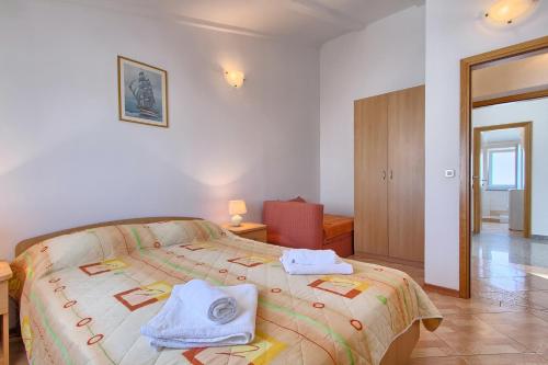 a bedroom with a large bed with towels on it at Apartmani Tony in Banjole