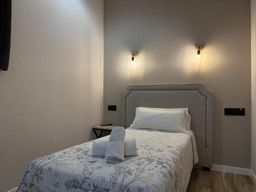 a bedroom with a bed with two towels on it at CC Opera Suites in Madrid