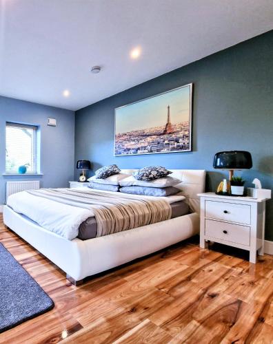 a bedroom with a large bed and a painting on the wall at Master bedroom with ensuite in Lucan