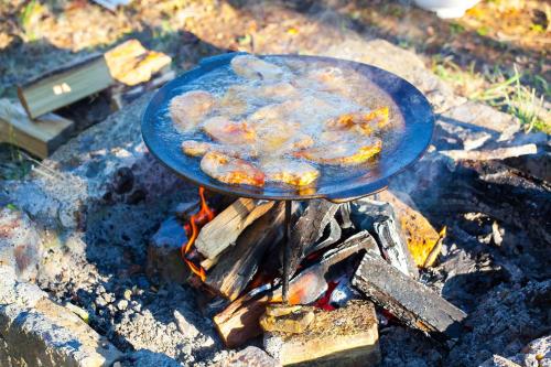 una sartén de comida en la parte superior de un fuego en Nyugalomsziget Nyaralóház, en Zalaszentlászló